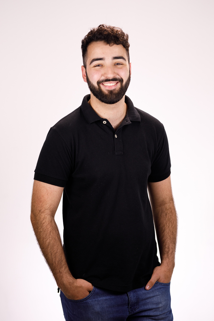 Bearded man in a black polo shirt smiling